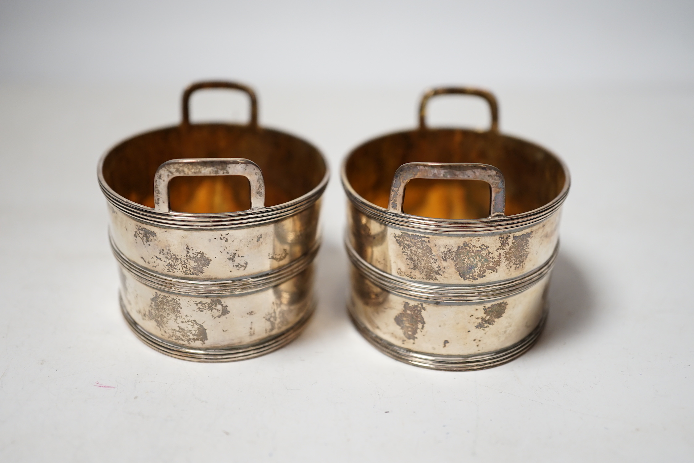 A pair of George III silver salts, modelled and oval two handled tubs, by John Emes, with reeded bands and engraved crest, 89mm.